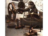 A native weaver of Ramallah winding a spindle by centuries old method. An early photograph.